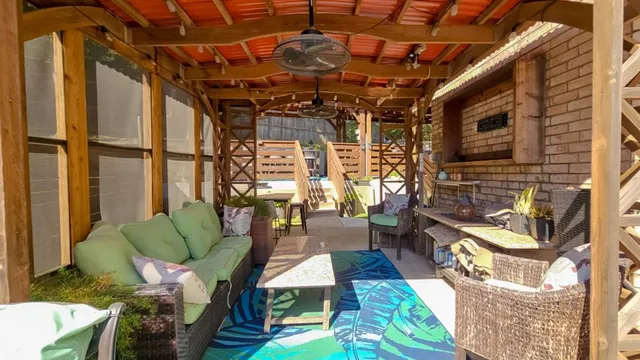 a view of a patio with table and chairs with wooden fence and plants