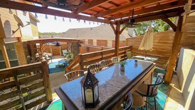 a view of a patio with table and chairs potted plants with wooden floor