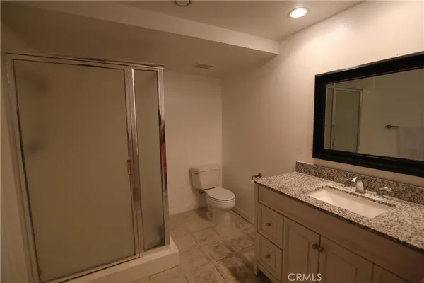 a bathroom with a granite countertop sink toilet and shower