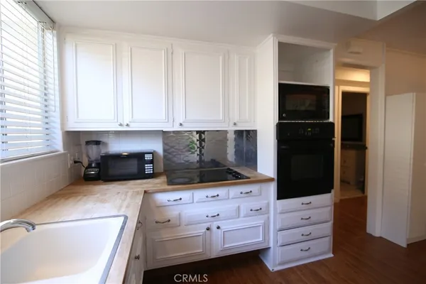 a kitchen with granite countertop white cabinets and refrigerator
