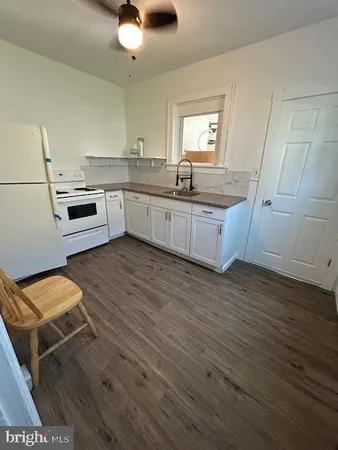 a kitchen with a sink cabinets and wooden floor