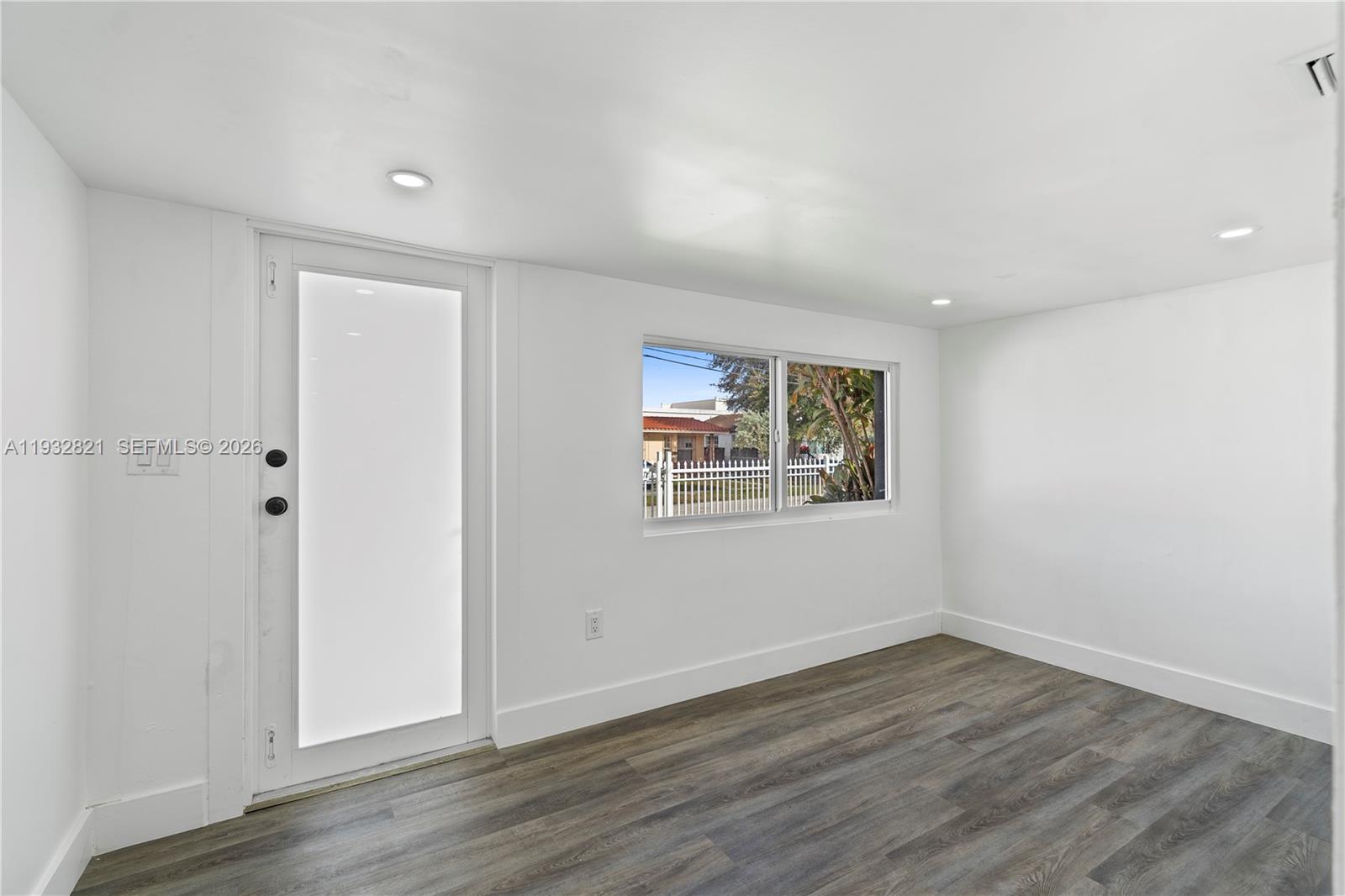 5658 Southwest 1st Street Miami, FL 33134 - Photo 12 of 50 an empty room with wooden floor and windows