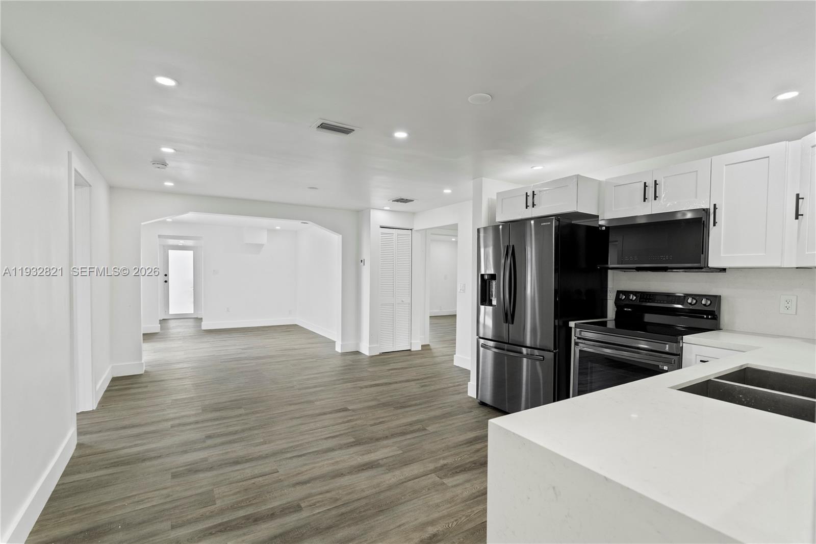 5658 Southwest 1st Street Miami, FL 33134 - Photo 20 of 50 a kitchen with a refrigerator a stove top oven and wooden floor