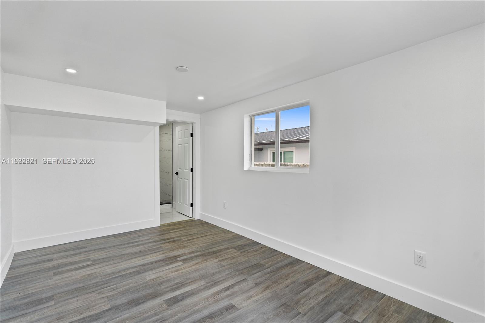 5658 Southwest 1st Street Miami, FL 33134 - Photo 30 of 50 a view of an empty room with wooden floor and a window