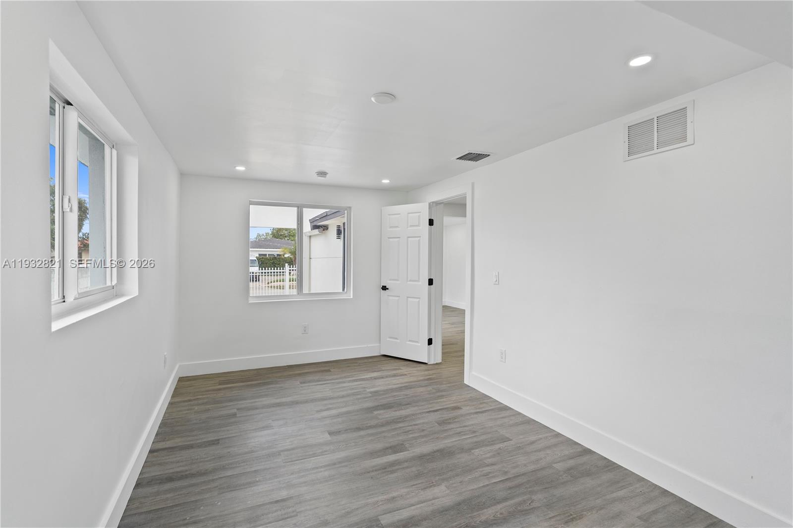 5658 Southwest 1st Street Miami, FL 33134 - Photo 35 of 50 a view of an empty room with wooden floor and a window