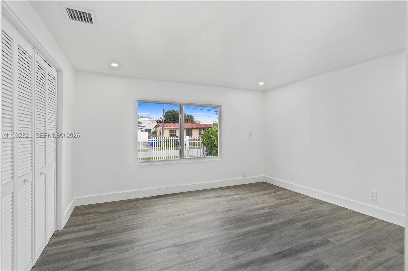 5658 Southwest 1st Street Miami, FL 33134 - Photo 37 of 50 an empty room with wooden floor and window