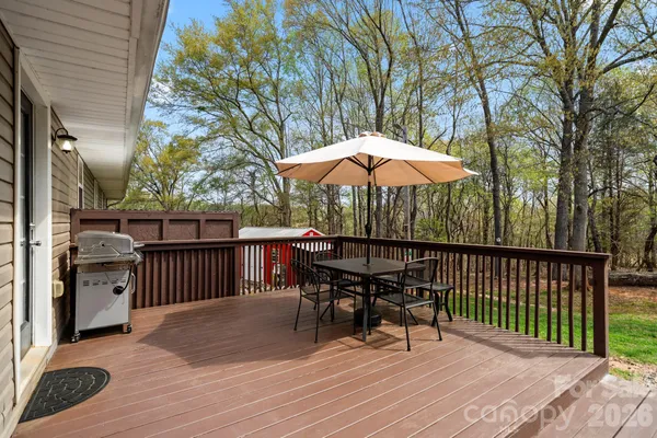 a view of backyard with deck and outdoor seating