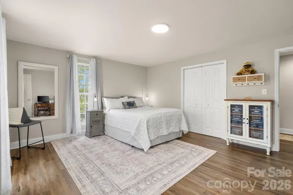 a bedroom with a large bed and a wooden floor