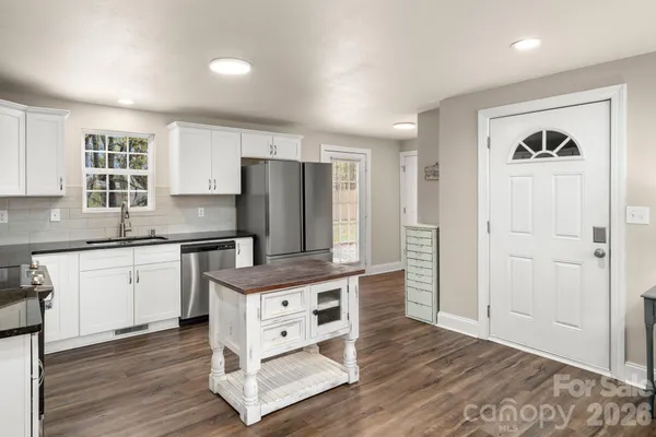 a kitchen with stainless steel appliances granite countertop a refrigerator and a stove top oven