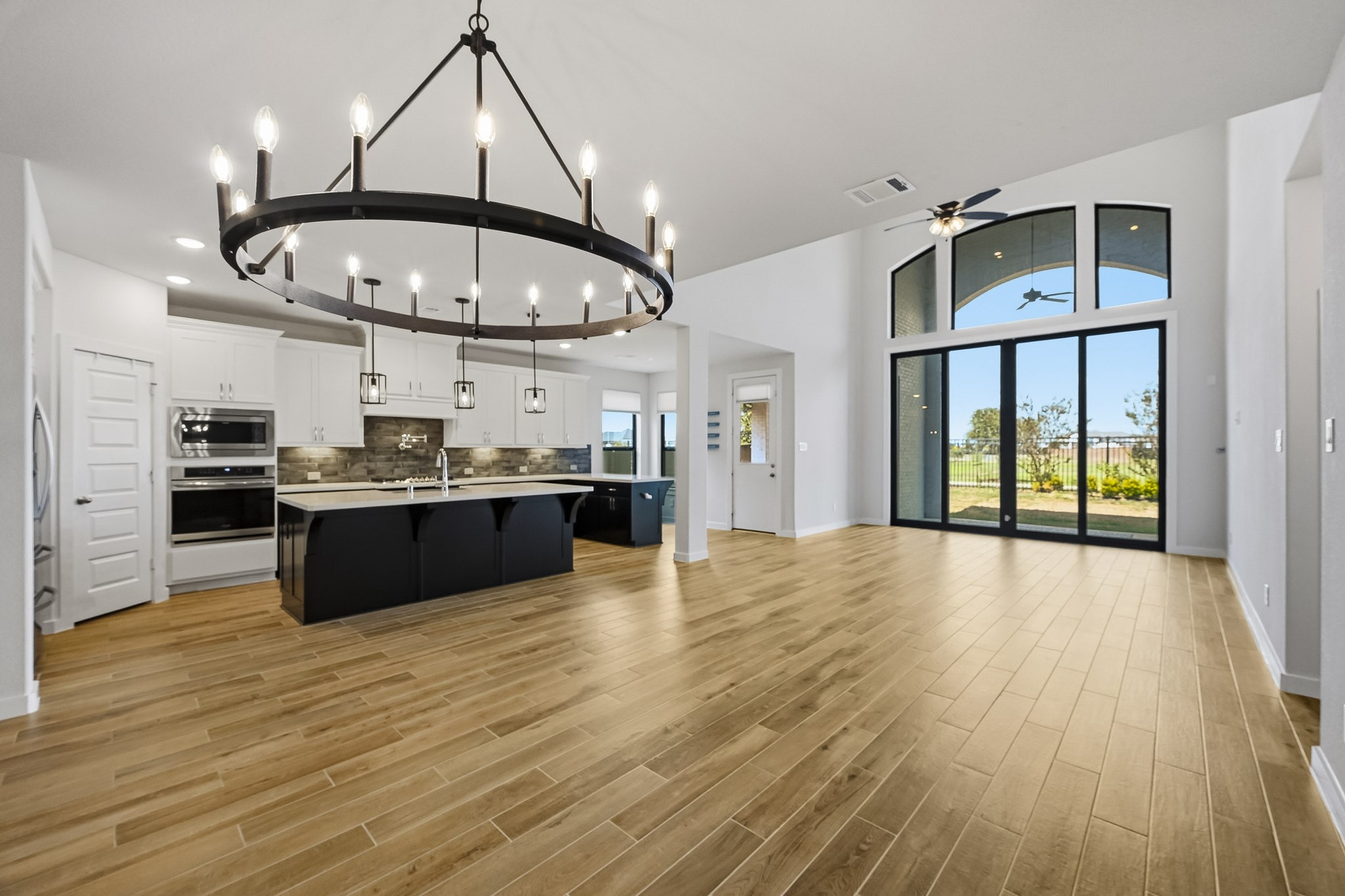 6718 Waxbill Road Katy, TX 77493 - Photo 4 of 30 Walking in, you are greeted by a light and open space! This huge open layout will not disappoint and offers high ceilings, recessed lighting, a beautiful chandelier, and large windows and sliding glass doors letting in tons of natural light.