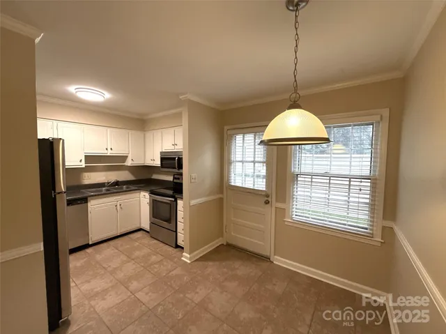 a kitchen with stainless steel appliances granite countertop a refrigerator a sink a stove and a window