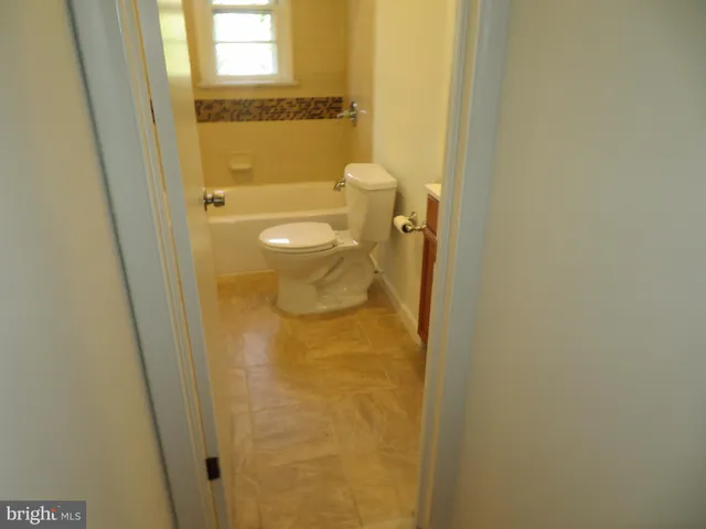 a bathroom with a granite countertop shower and a toilet