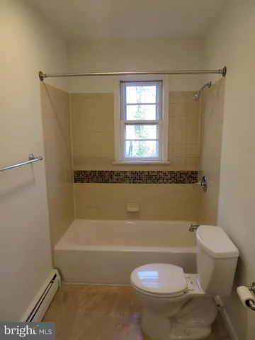 a bath room with a toilet and a bath tub
