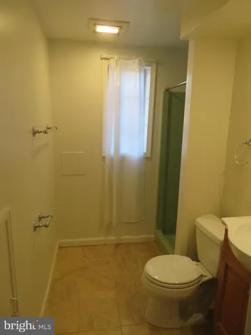 a view of empty room with wooden floor and a sink