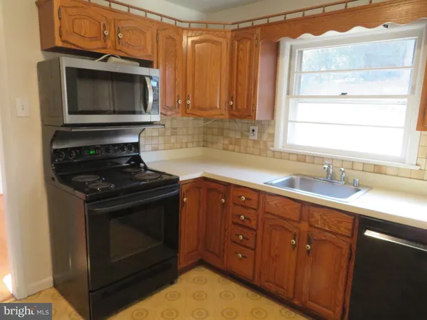 a kitchen with granite countertop a stove microwave and sink