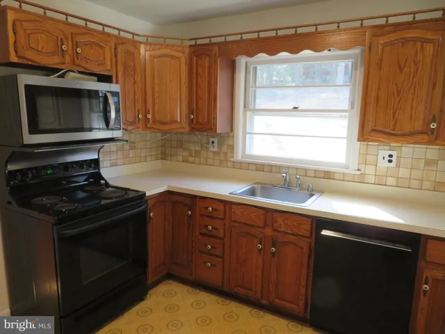 a kitchen with wooden cabinets and a stove top oven
