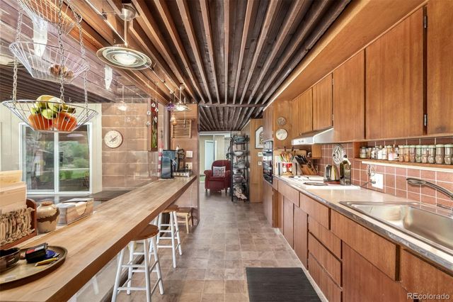 a bed sitting in a spacious bedroom next to a window and a chandelier
