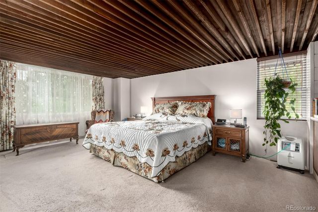 a large bed sitting in a bedroom next to a window