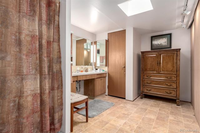 a spacious bedroom with a bed and a chandelier