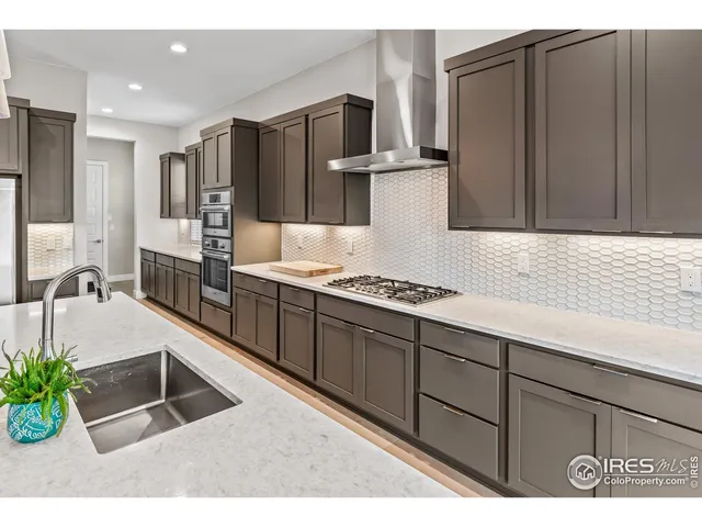 a kitchen with kitchen island granite countertop a sink cabinets and stainless steel appliances