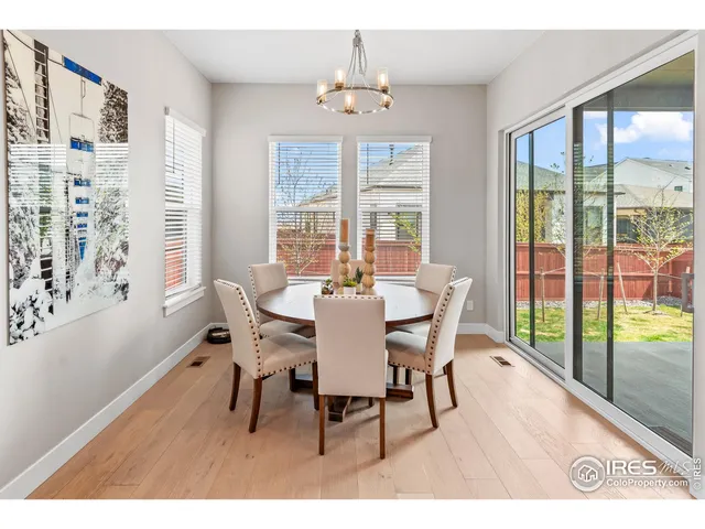 a dining room with furniture a chandelier and wooden floor