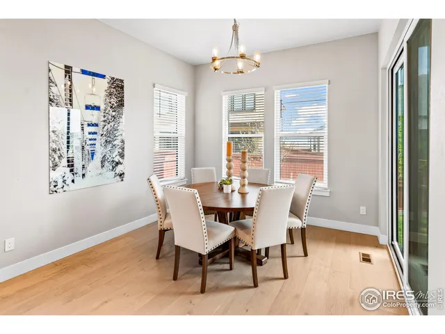 a dining room with furniture a chandelier and wooden floor
