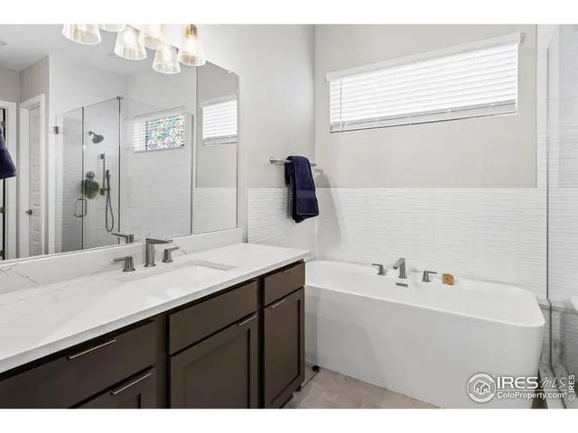 a bathroom with a sink vanity tub and a mirror