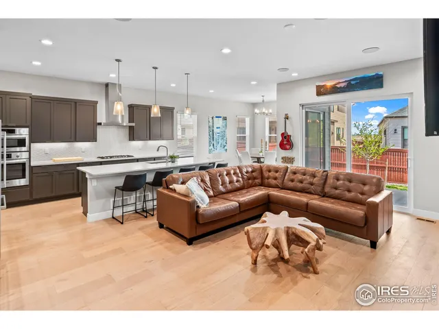 a living room with furniture kitchen view and a chandelier