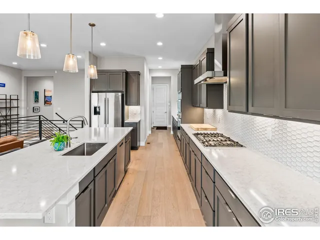 a kitchen with kitchen island granite countertop lots of counter top space a sink and stainless steel appliances
