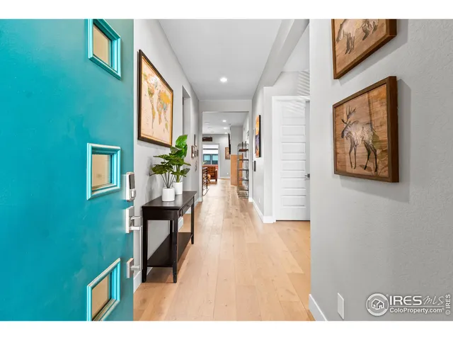 a view of a hallway with wooden floor and furniture