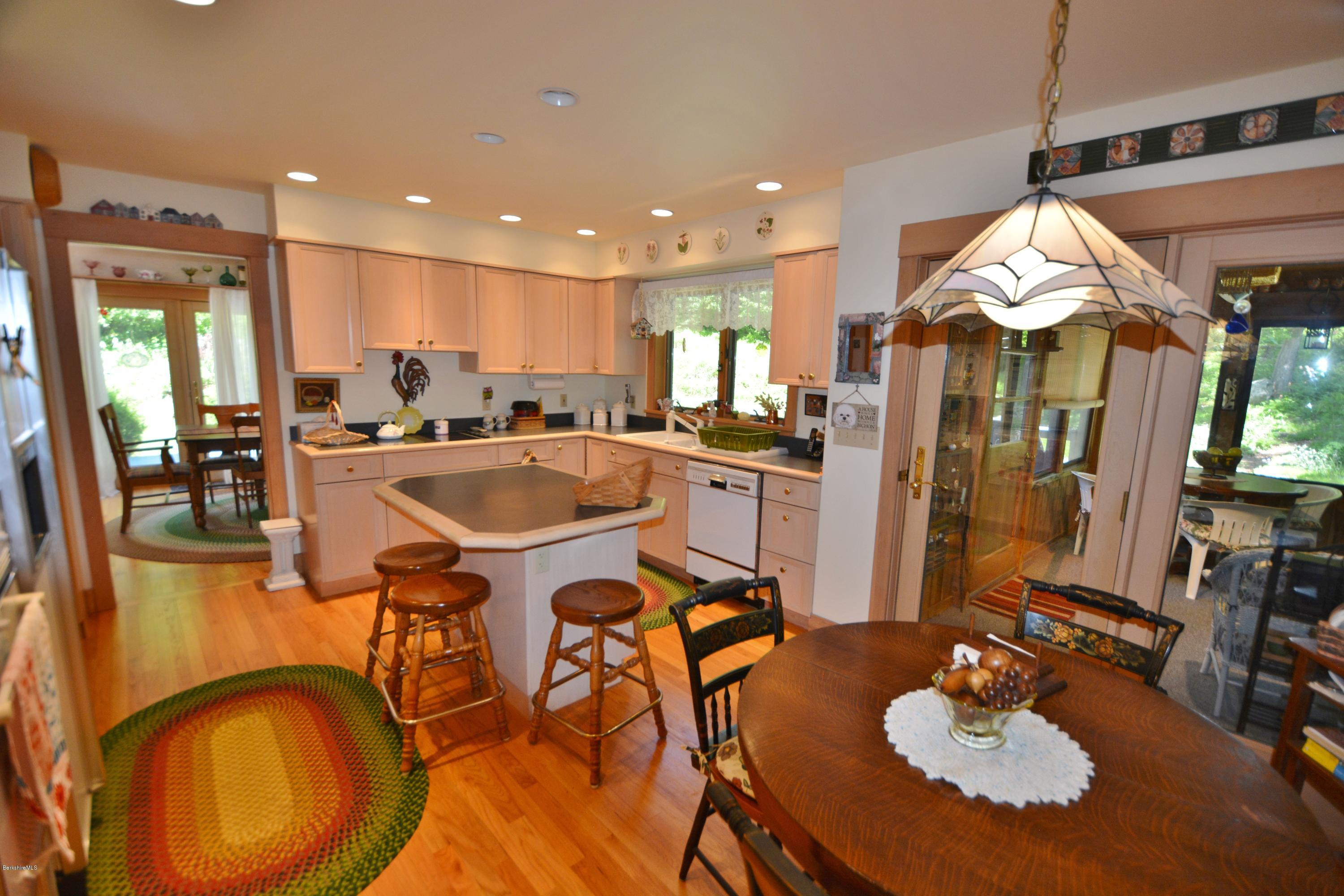 1304 West Center Road Otis, MA 01253 - Photo 7 of 28 a kitchen with stainless steel appliances granite countertop a sink a stove a dining table and chairs