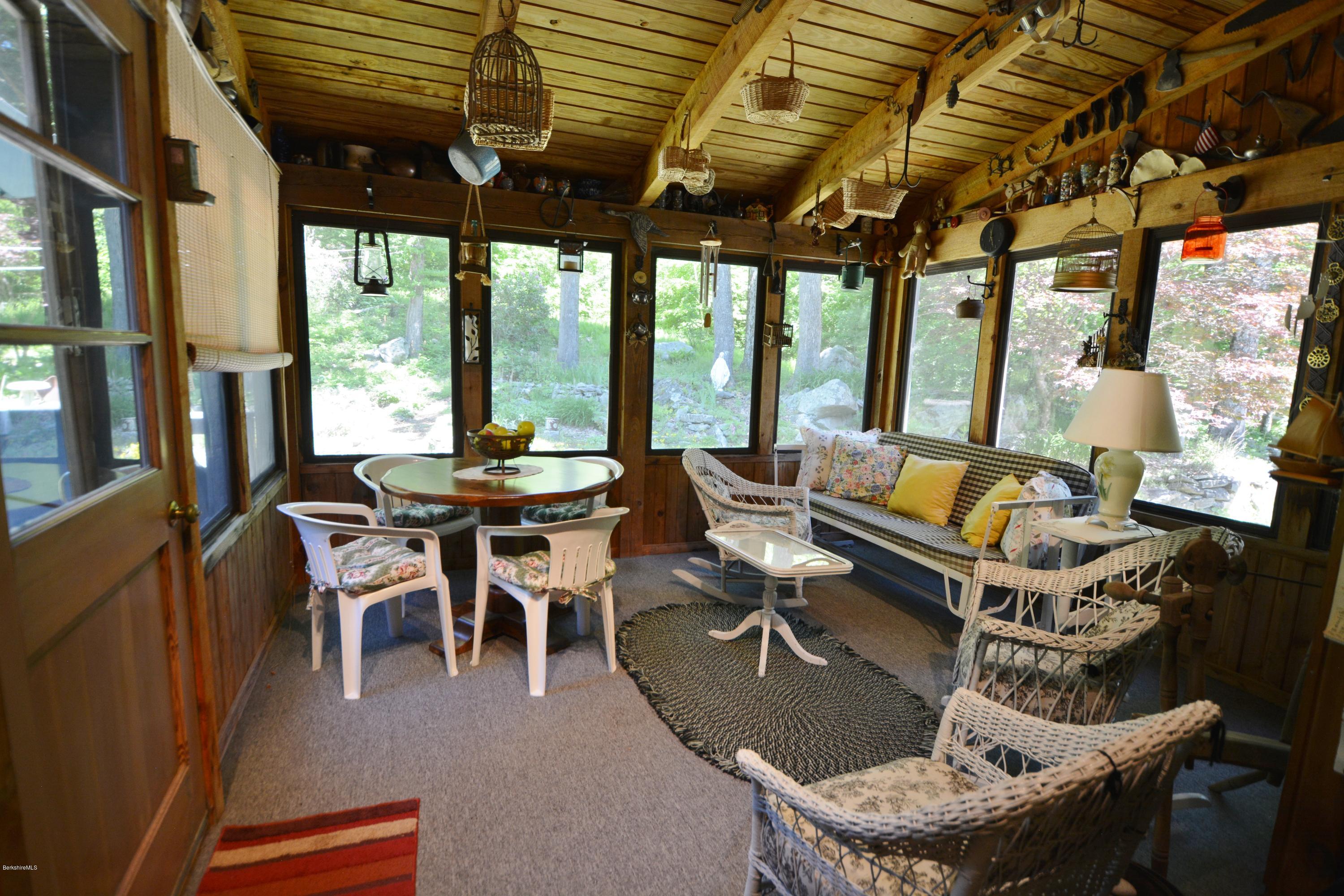 1304 West Center Road Otis, MA 01253 - Photo 9 of 28 a living room with couches a dining table and chairs with outer view