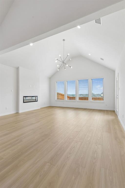 1429 Companero Street Haslet, TX 76052 - Photo 12 of 35 an empty room with a kitchen space and wooden floor