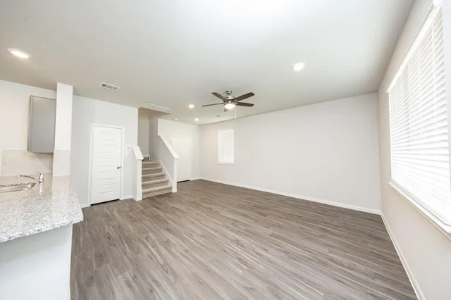 a living room with stainless steel appliances kitchen island hardwood floor and a sink