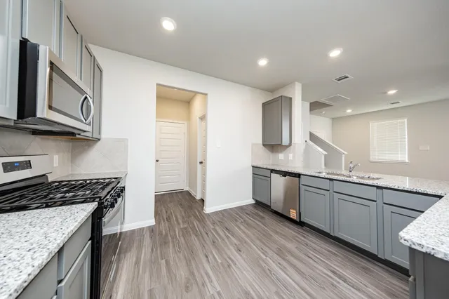 a kitchen with a sink cabinets and wooden floor