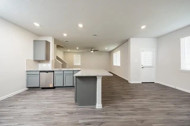 a kitchen with a sink and wooden floor