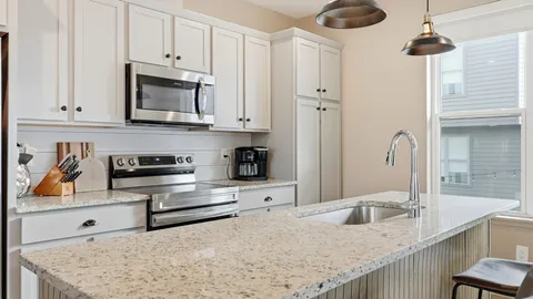 a kitchen with stainless steel appliances granite countertop a sink and a stove