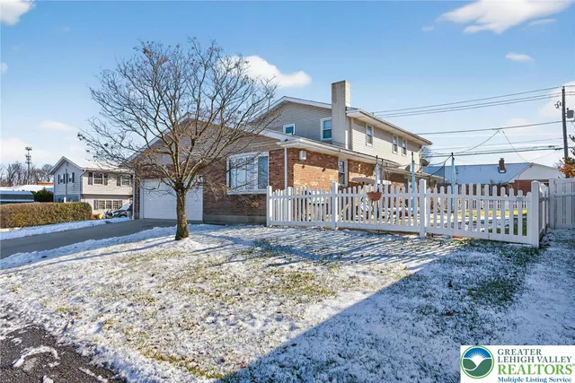 a view of a house with a yard covered in snow