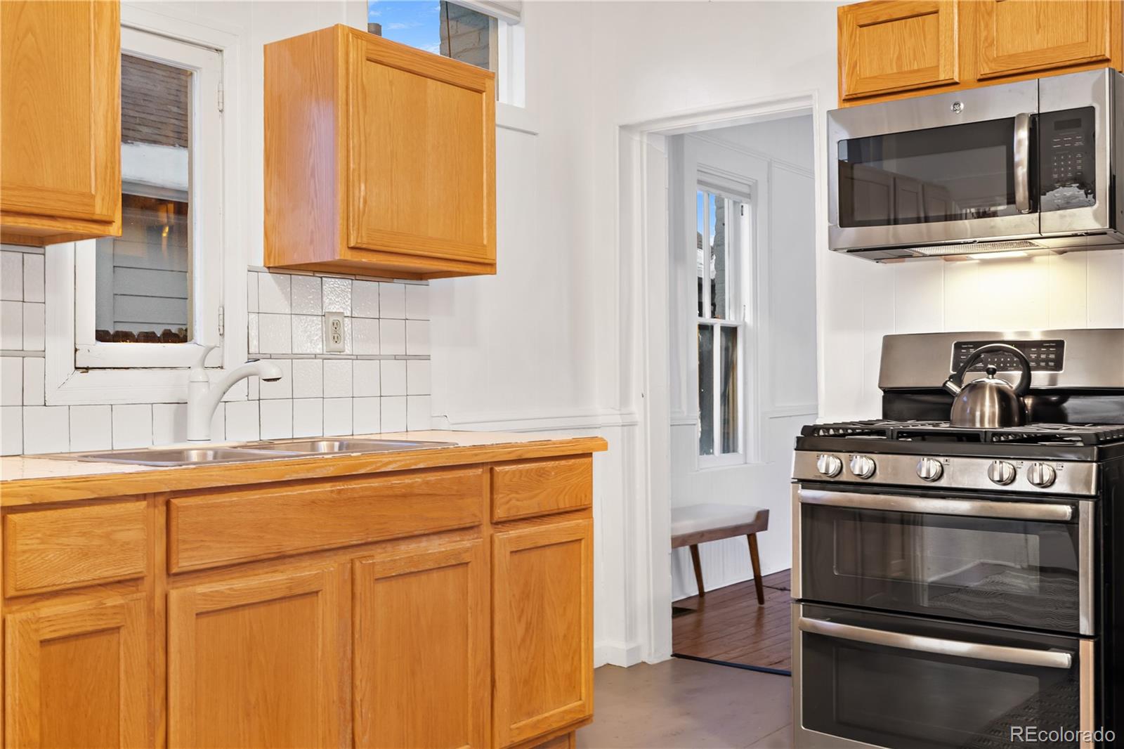 4743 Tejon Street Denver, CO 80211 - Photo 15 of 30 a kitchen with stainless steel appliances granite countertop a stove and a microwave