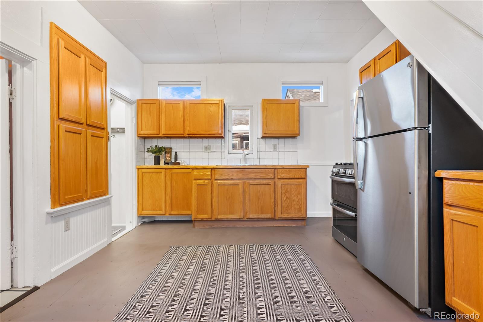 4743 Tejon Street Denver, CO 80211 - Photo 16 of 30 a kitchen with stainless steel appliances granite countertop a sink stove and refrigerator