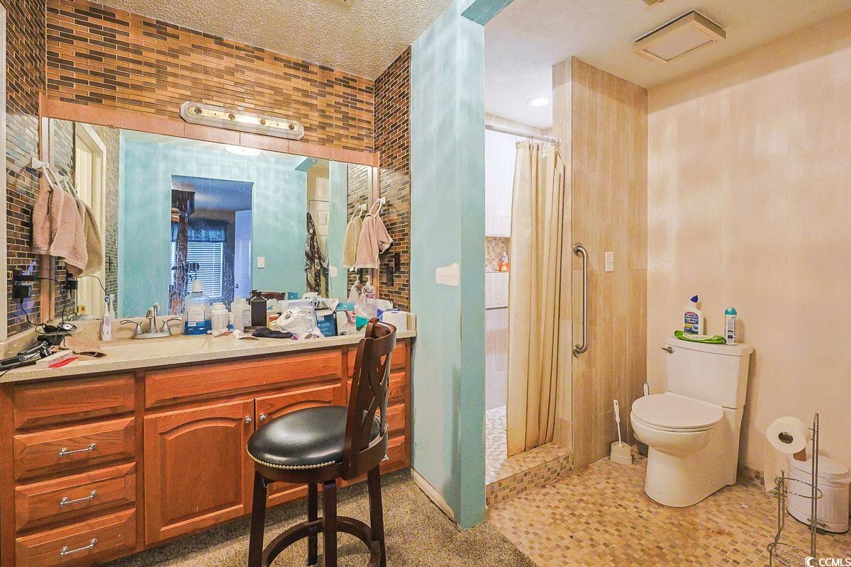 210 Rail Street Longs, SC 29568 - Photo 18 of 32 Bathroom with a stall shower, vanity, light tile patterned floors, a textured ceiling, and tile walls