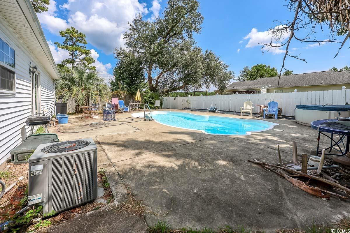 210 Rail Street Longs, SC 29568 - Photo 29 of 32 View of swimming pool featuring a patio area, a fenced backyard, and a hot tub
