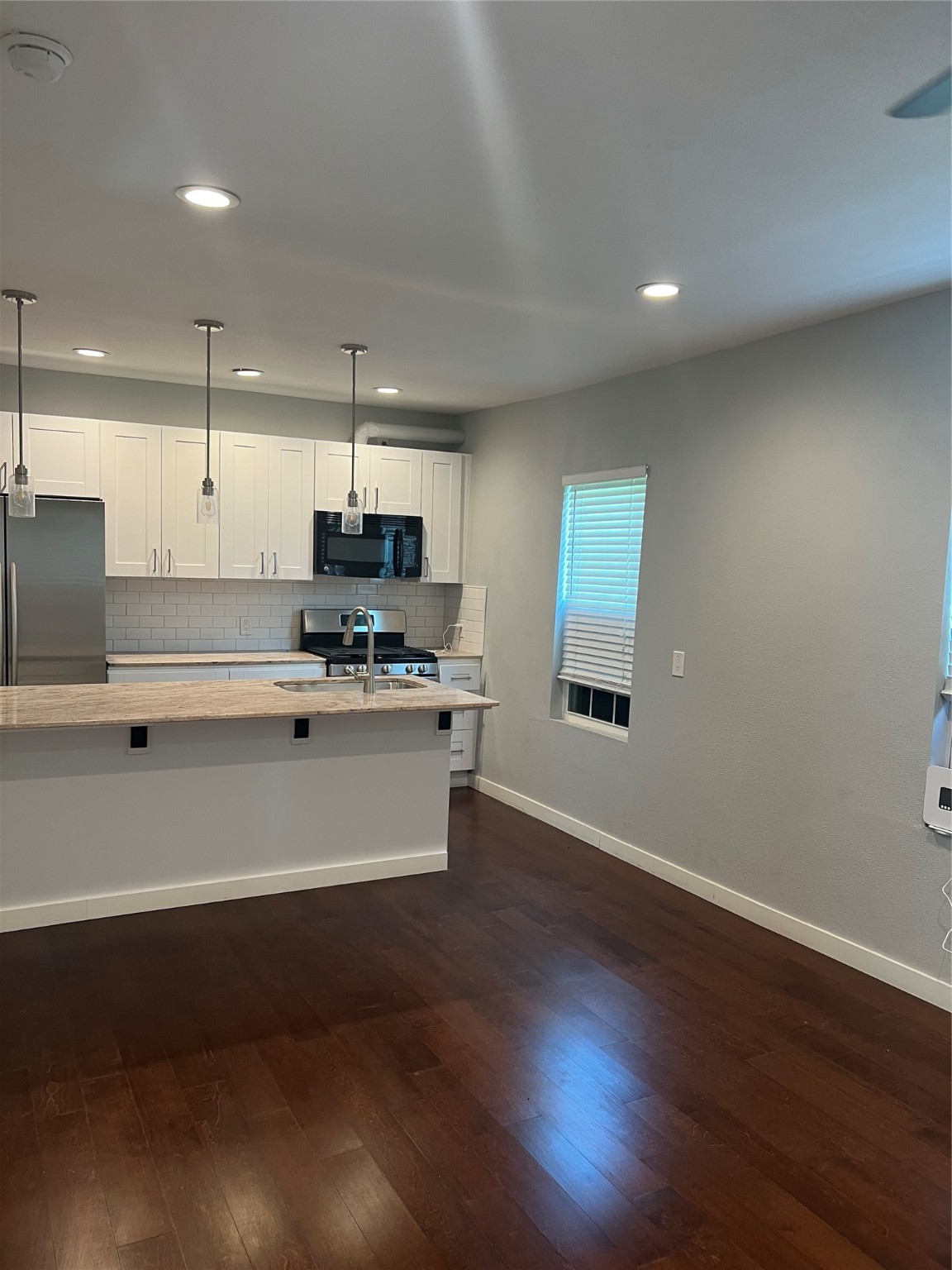 2812 Live Oak Street Houston, TX 77004 - Photo 5 of 6 a large kitchen with stainless steel appliances a large counter top a stove a refrigerator and a microwave