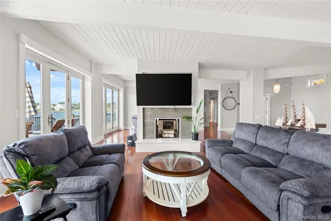 a living room with furniture a flat screen tv a rug and a fireplace