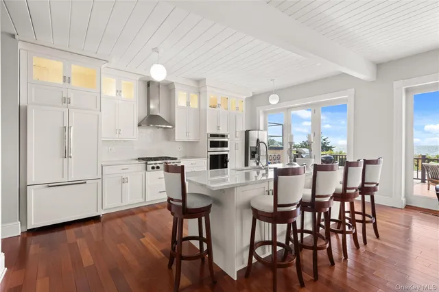 a kitchen with stainless steel appliances a dining table chairs and wooden floor