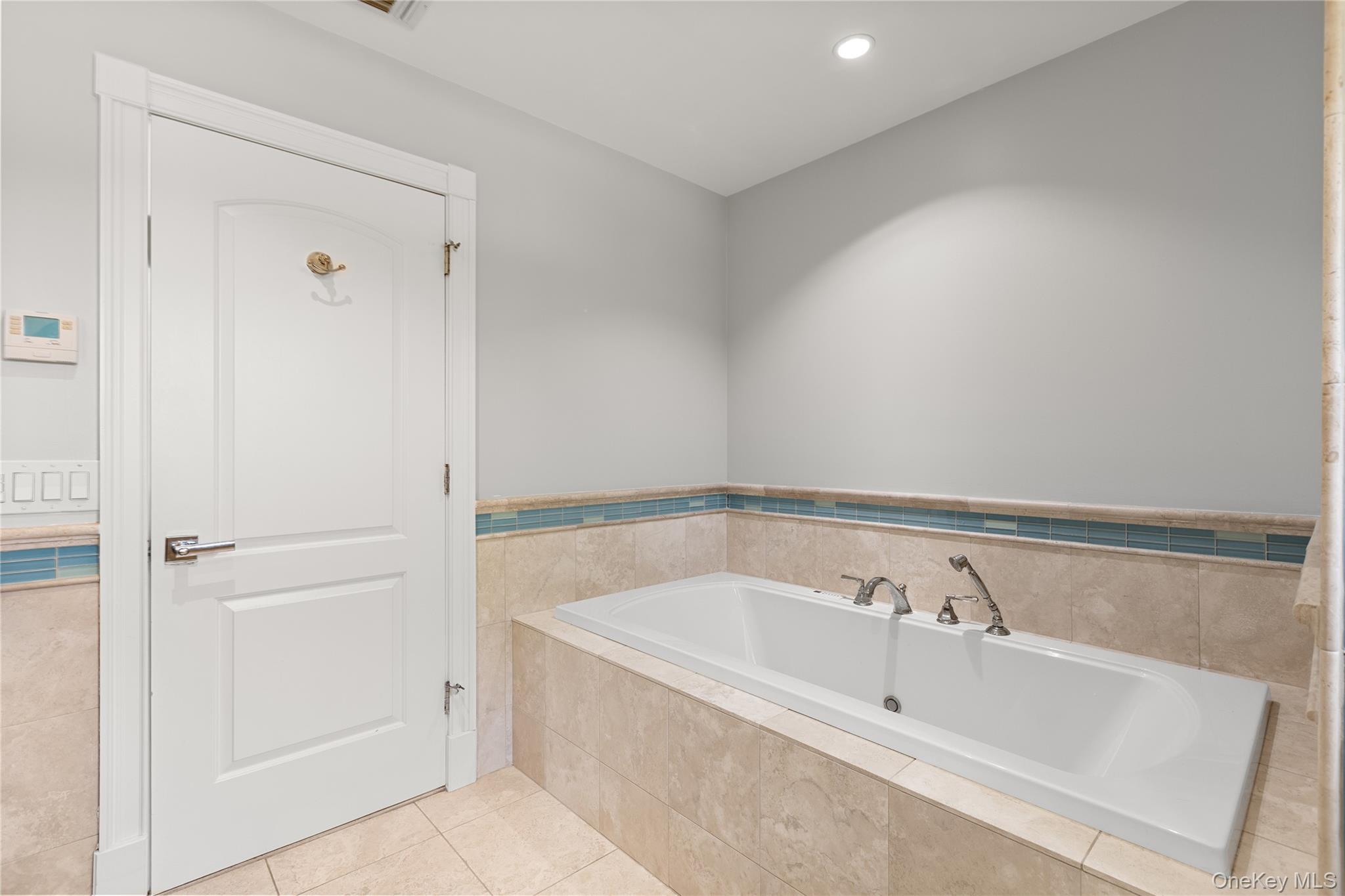 10 Great Cove Lane Islip, NY 11751 - Photo 20 of 31 a white bath tub sitting in a en suite bathroom