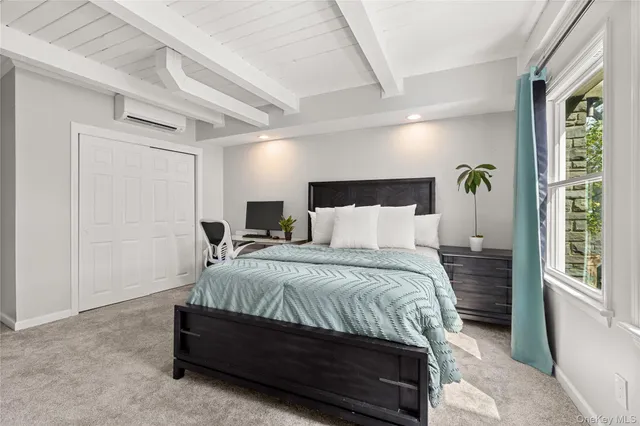 a bedroom with a bed and dresser with wooden floor