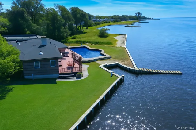 an aerial view of a house with a garden and lake view