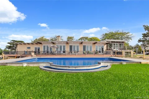 a view of lake with a big yard and large trees
