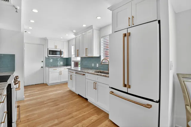 a kitchen with white cabinets and white appliances